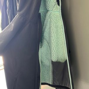 Grey winter jacket with teal fur inside.